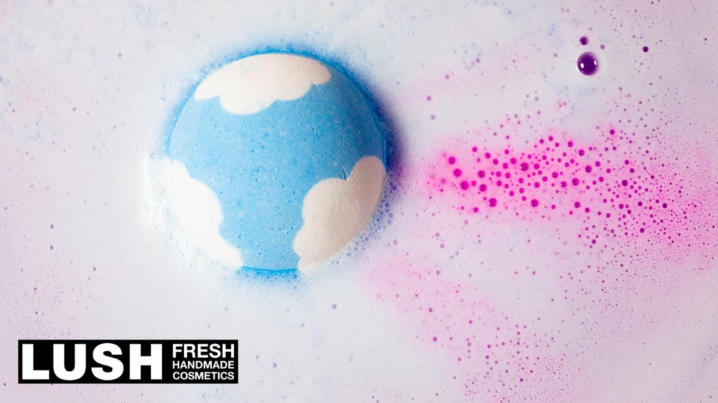 Lush logo. blue bath bomb in pink water signifying an inclusive world event