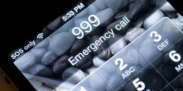 A smartphone screen displays an emergency call interface with "999" entered, "Emergency call" text, emergency text options, and a "SOS only" signal indicator.