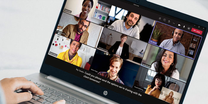 A person participates in a video conference on a laptop with nine others, each shown in their own video window, while CART captioning provides real-time subtitles for improved accessibility.