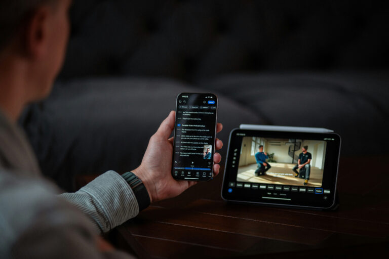 man holds phone with captions against video display
